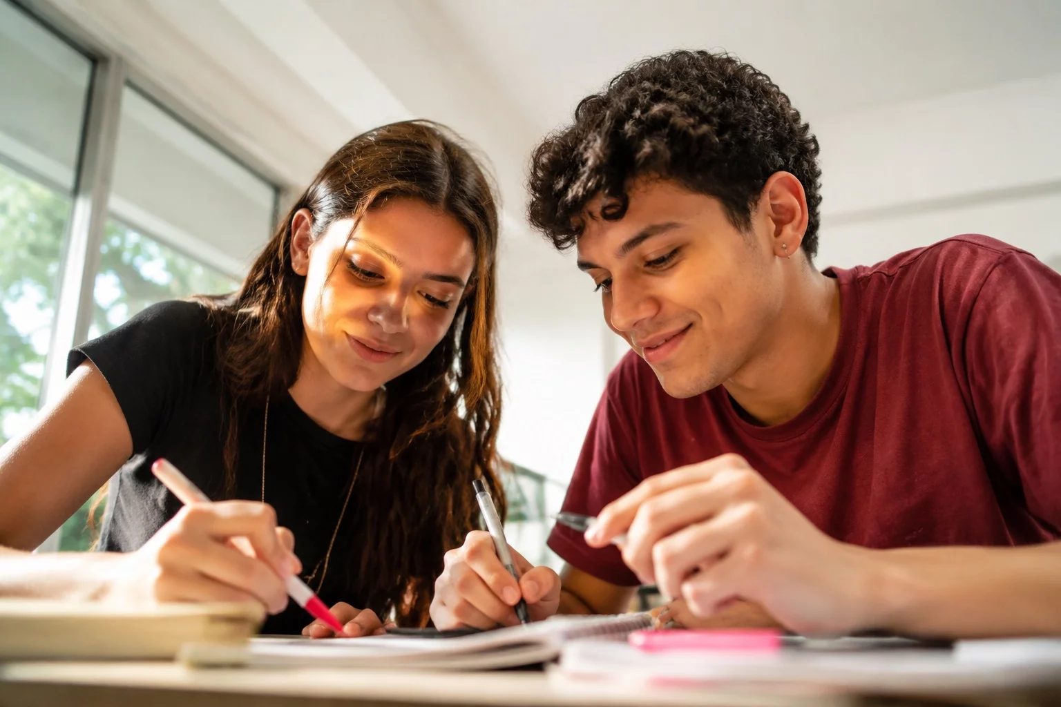 Dois estudantes preparando um debate com cadernos e marcadores